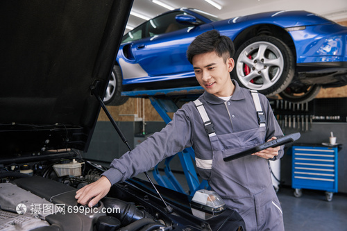 汽车修理工人使用智能设备检测汽车